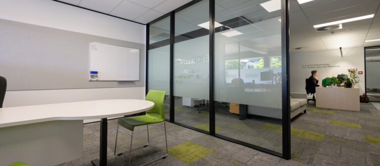 Meeting room in a office fitout in Nelson, featuring black aluminium partitioning and desk.