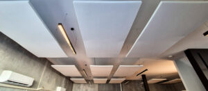 White acoustic panels hung from the ceiling in an office space