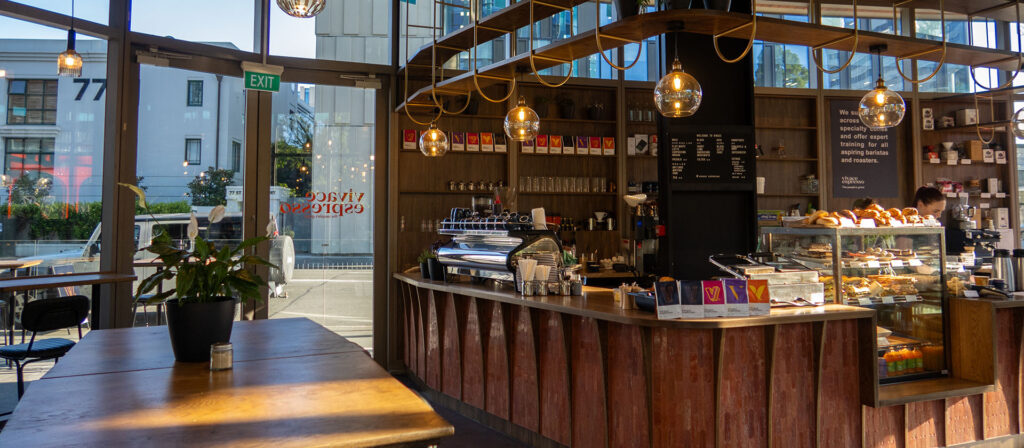 Counter bar with a coffee machine and food cabinet in a new café in Christchurch.