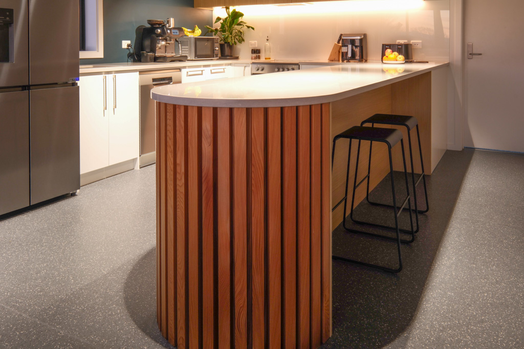 Cafe counter with a coffee machine on a timber counter top, and warm down lights.