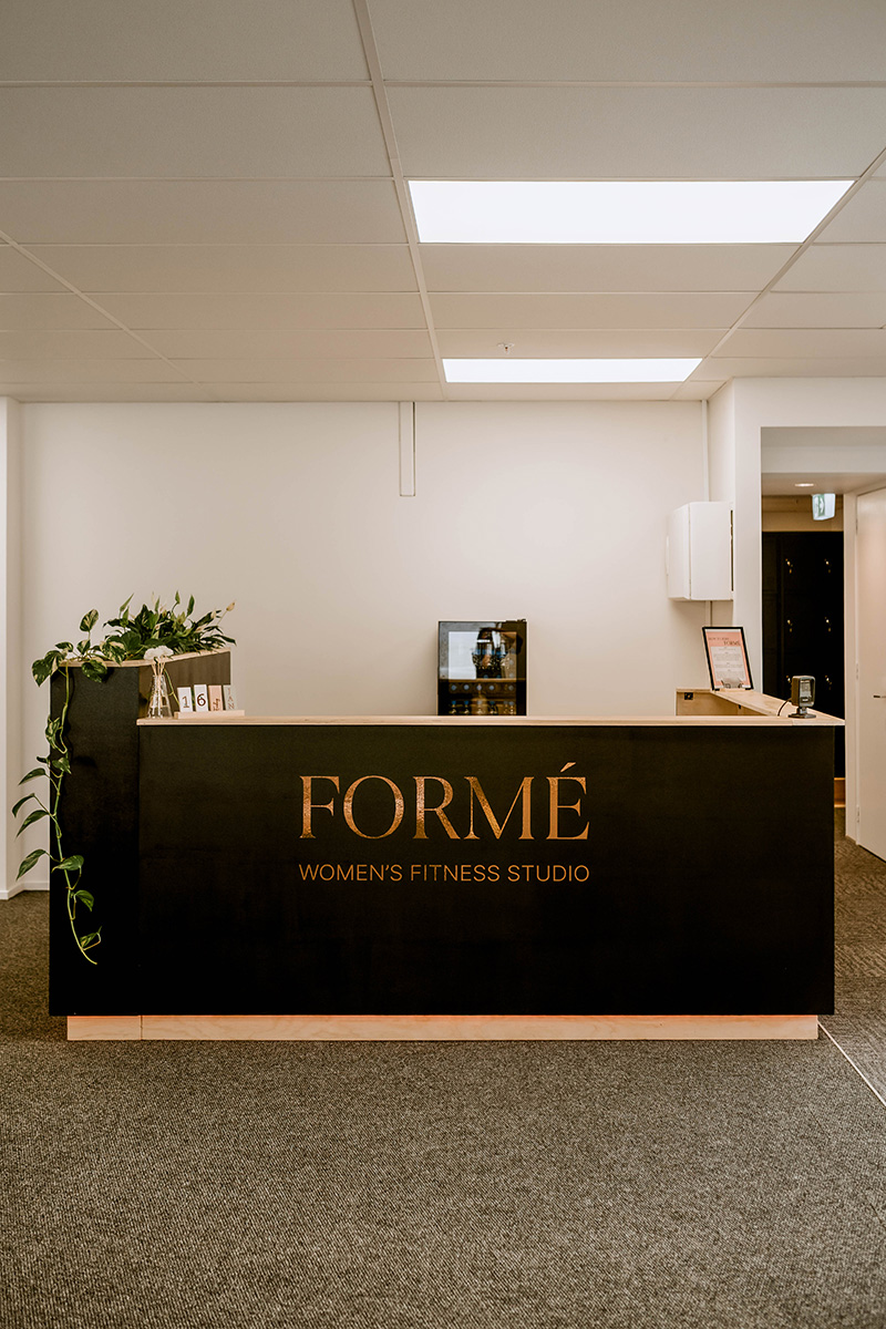 Reception area of a nail salon with bench seating along the wall. 