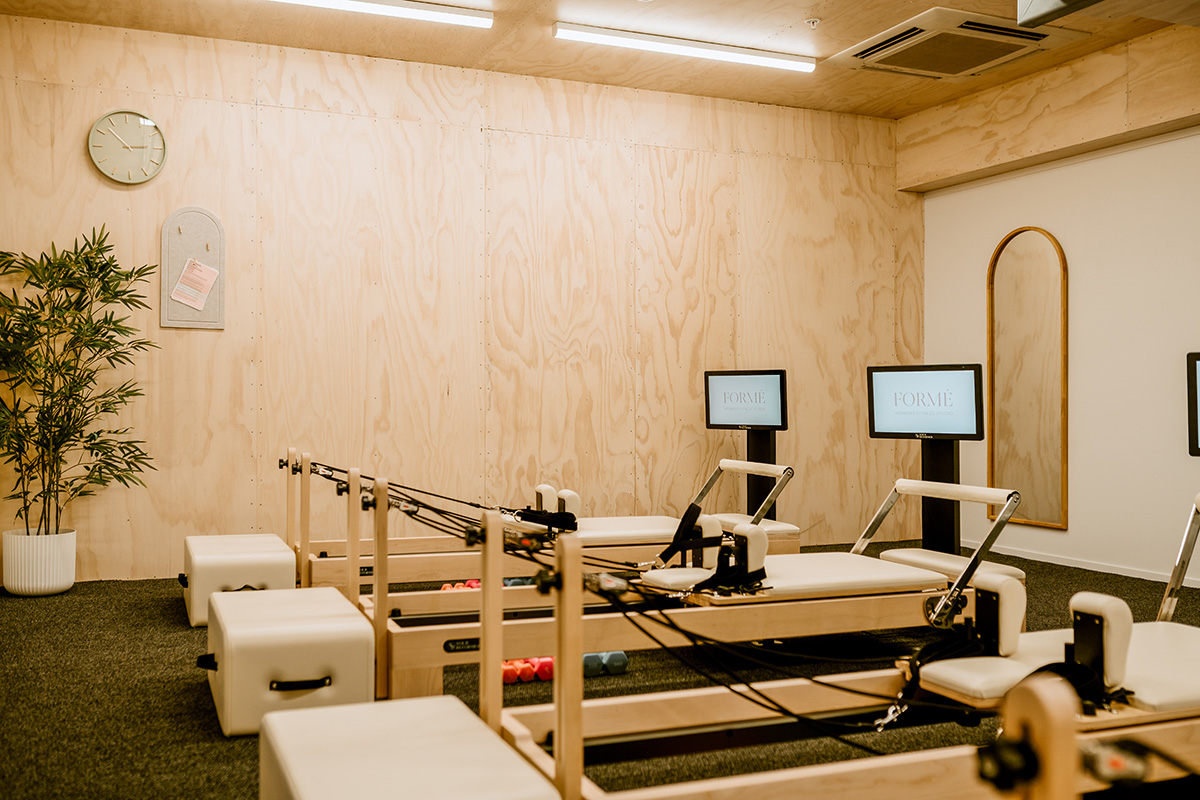 Cafe counter with a coffee machine on a timber counter top, and warm down lights.