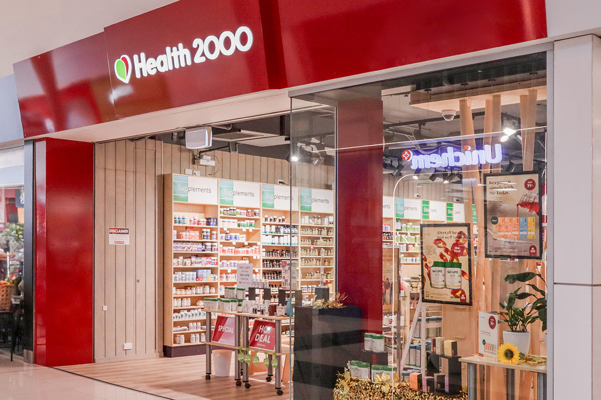 Cafe counter with a coffee machine on a timber counter top, and warm down lights.