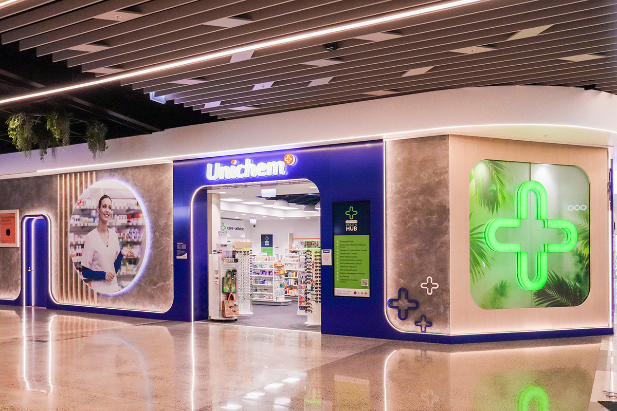 Cafe counter with a coffee machine on a timber counter top, and warm down lights.